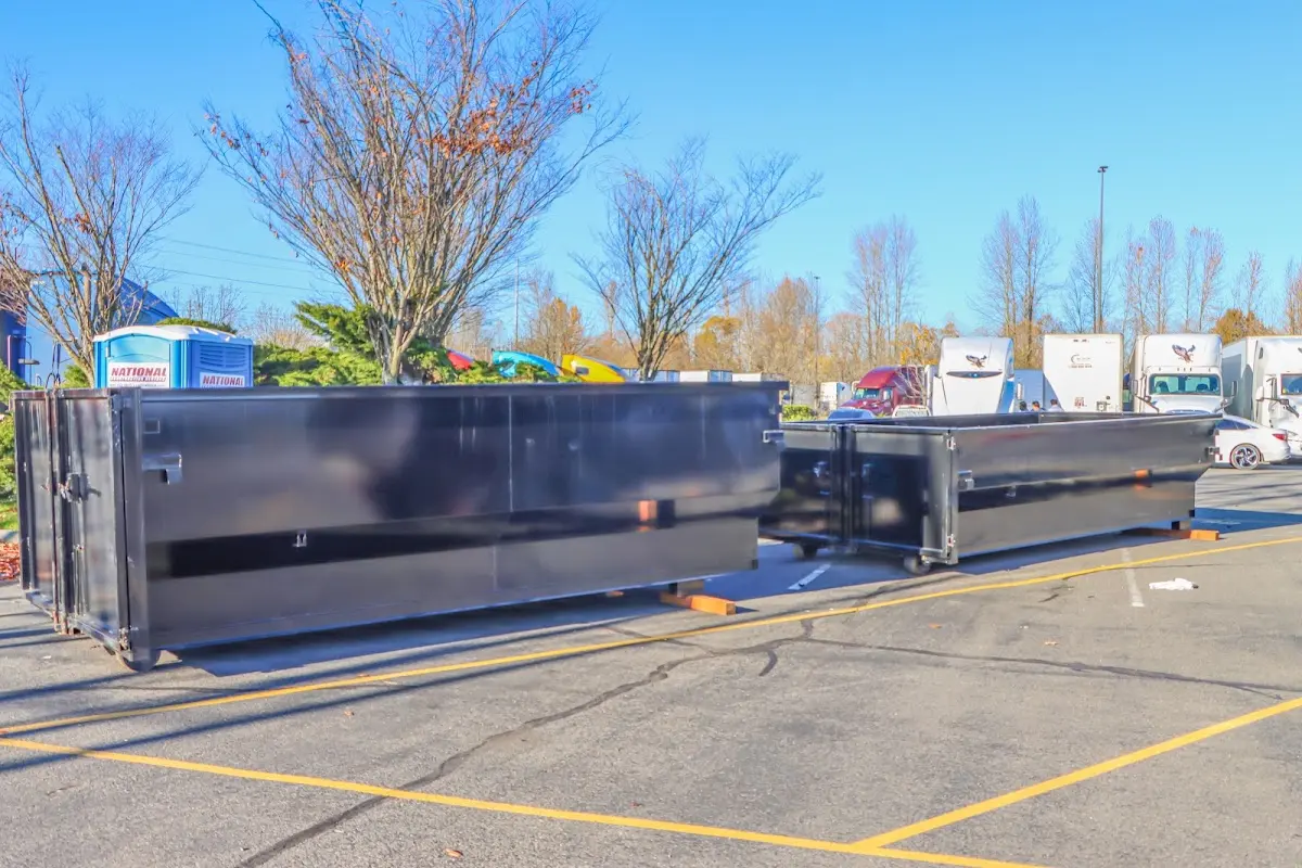 Professional dumpster rental service with roll-off container on residential driveway in Hoboken